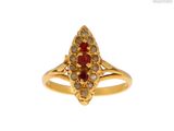 gros plan d'une bague en or avec une pierre rouge