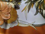 a close up of a scarf with a flower on it