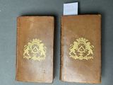 deux vieux livres ornés de dorures, posés sur une table