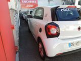 a small white car parked on the side of the street