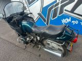 a blue motorcycle parked in front of a graffiti wall