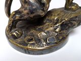 a bronze statue of a horse and a dog on a rock