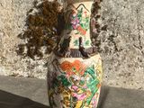 un vase posé sur une surface en béton, avec un mur en arrière-plan
