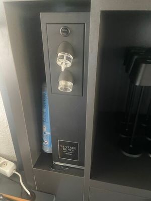 a coffee maker and a cup holder in a cabinet
