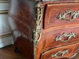 a marble top chest of drawers on a wooden floor