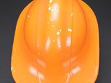 an orange hard hat sitting on top of a black surface