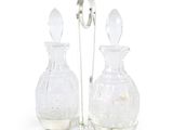 paire de carafes en verre transparent posées sur un socle et dotées d'une poignée en argent