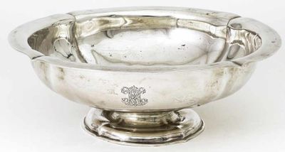 un bol ancien en argent posé sur un socle, sur fond blanc