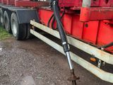 un gros camion rouge équipé d'une grue à l'arrière