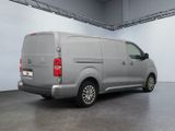 grey van parked in a large room with a white wall