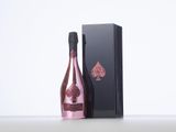 a bottle of pink wine sitting next to a black box