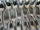 a lot of silver spoons and forks on the table