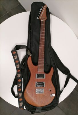a guitar that is sitting on a table next to a guitar case
