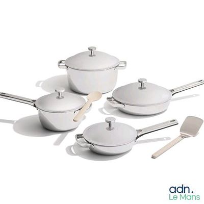 plusieurs casseroles et poêles blanches posées sur une table blanche