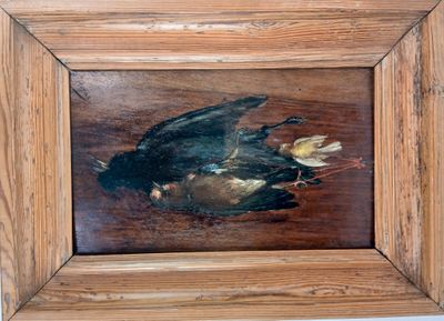 une photo d'un tableau représentant un oiseau mort, dans un cadre en bois