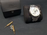a watch that is sitting next to a leather case