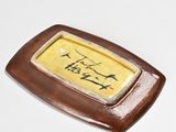 a small plate with writing on it sitting on a table