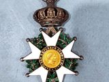 a silver and gold medal with a crown on it