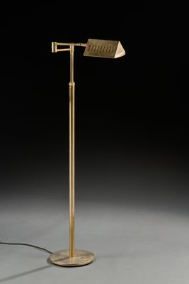 un lampadaire en laiton avec un abat-jour blanc et un fond noir
