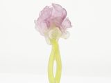 a green vase with a pink flower on a green base