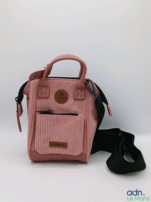 un sac à main rose avec une bandoulière noire et une paire de chaussures