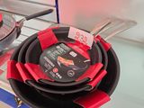 plusieurs casseroles et poêles exposées dans un magasin, accompagnées d'étiquettes de prix