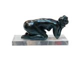 statue d'une femme penchée en avant, posée sur un socle en marbre