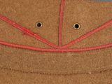 a close up of a brown hat with red stitching on it