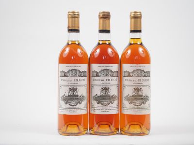 trois bouteilles de vin posées les unes à côté des autres sur une surface blanche