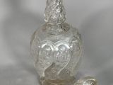 a clear glass bottle with a handle on a table