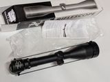 Le fusil est posé sur la table, à côté de la boîte.