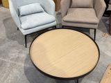 trois chaises et une table dans un entrepôt, avec des cartons en arrière-plan