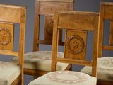 four wooden chairs with upholstered cushions and a star design on the back