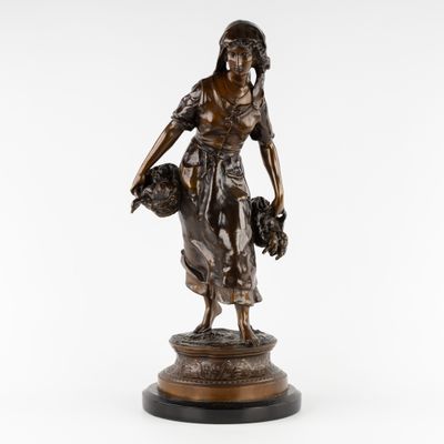 une statue en bronze représentant une femme tenant un panier de fleurs