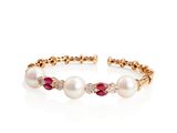 a close up of a bracelet with pearls and diamonds on a white background
