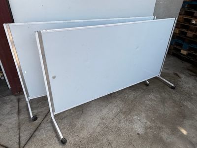 two white boards sitting on top of each other in a garage