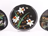 three black and white plates with flowers and birds on them
