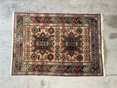 un vieux tapis posé à même le sol, sur fond blanc