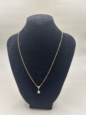 un collier en or orné d'un diamant blanc sur un mannequin noir