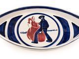 une assiette bleue et blanche sur laquelle est représenté un homme et une femme