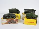 trois véhicules militaires miniatures sont posés sur une boîte