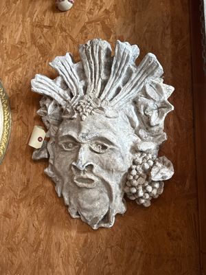 a statue of a man on the wall next to a clock