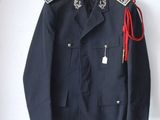 navy blue military jacket with a red cord on a hanger