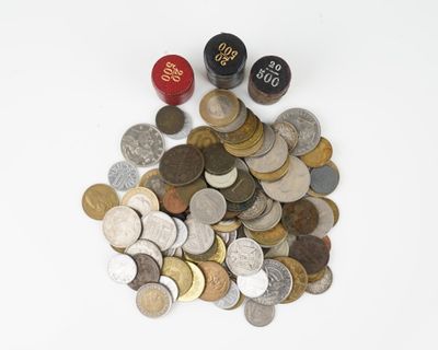 un tas de pièces et de dés posés sur une surface blanche