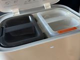 a small refrigerator with two containers inside of it