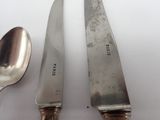 two spoons and a knife on a white table