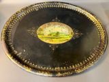 a silver tray with a picture of a field on it