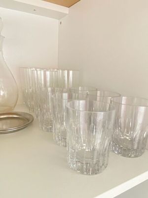 plusieurs verres et un pichet posés sur une étagère dans une pièce
