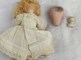 a doll that is laying on the ground next to shells