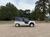 a small blue and white jeep parked in a parking lot